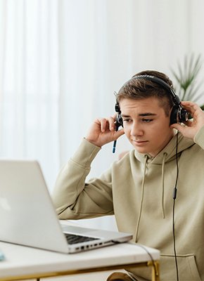 Adolescente estudiando desde casa con una laptop en su colegio virtual